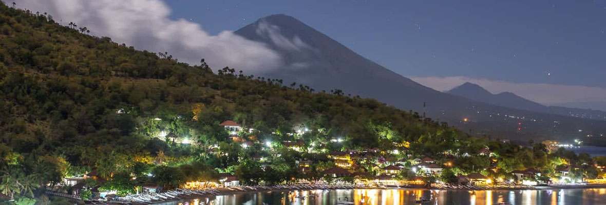 Jemeluk Beach and beautiful Agung volcano with a stars sky